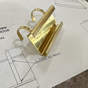 Gold door handle on a piece of paper with technical drawings