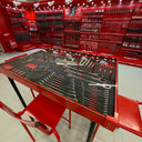 Red tool chest with tools on a white floor
