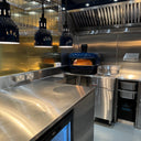 Modern kitchen with stainless steel appliances and a pizza oven.