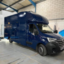 Blue van with 'Black Pig' branding inside a warehouse.